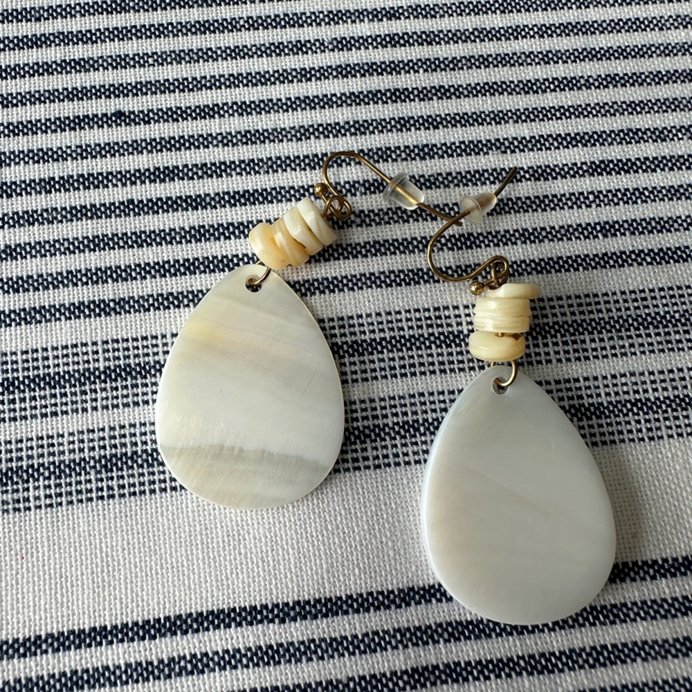Cream color teardrop shaped earrings.